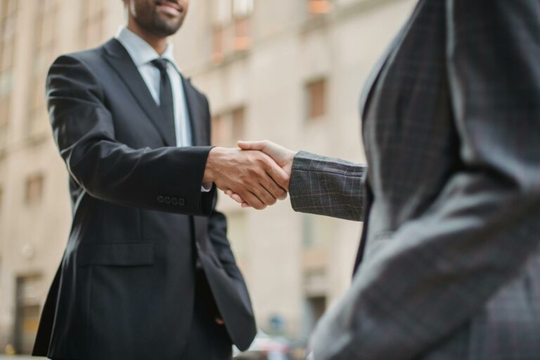 Deux professionnels se serrent la main après évaluation de la solvabilité entreprise et accord de crédit commercial