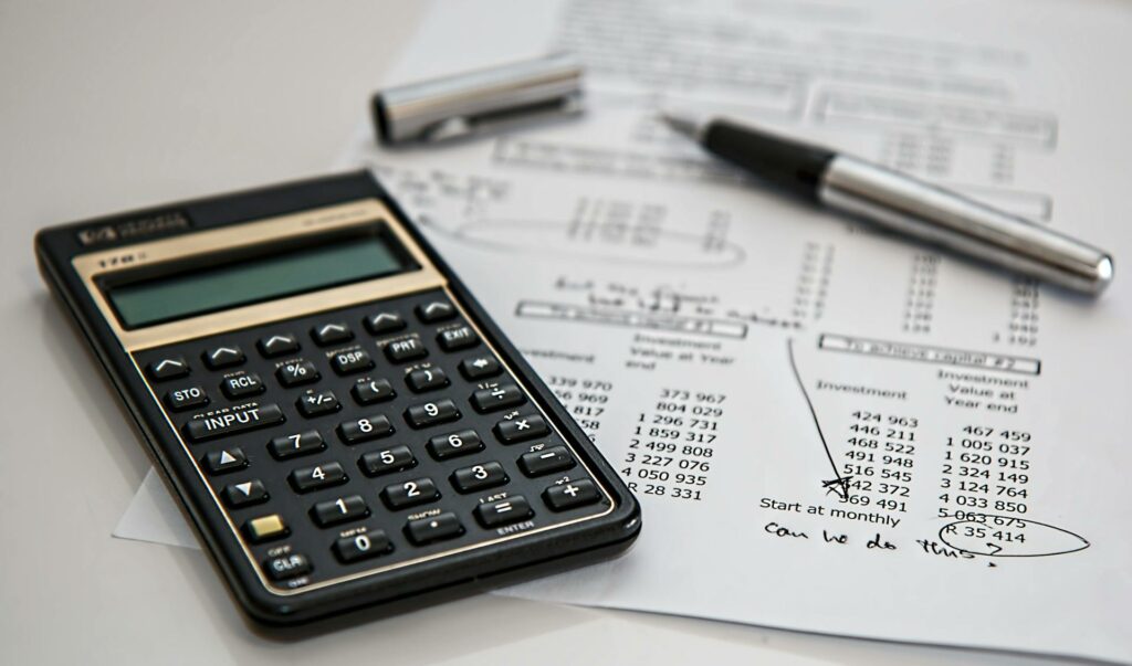 Calculatrice et facture sur un bureau pour illustrer le calcul pénalités de retard entre professionnels