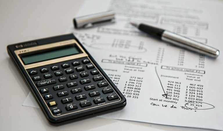 Calculatrice et facture sur un bureau pour illustrer le calcul pénalités de retard entre professionnels