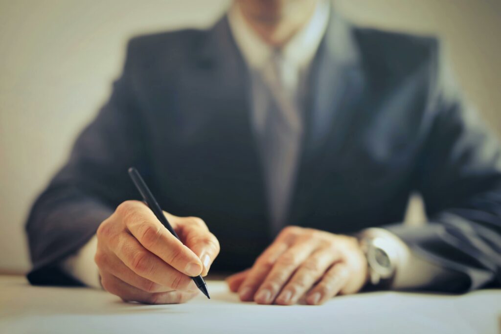Homme entrain de rediger une mise en demeure facture impayée